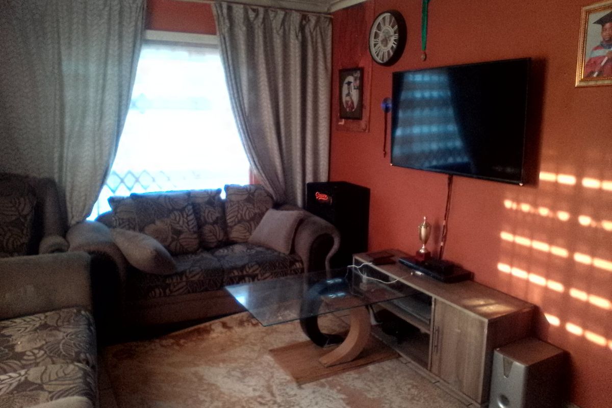 A living room featuring tiled flooring and window treatments, providing a functional space for relaxation and entertainment.