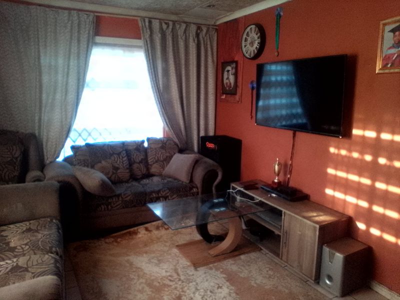 A living room featuring tiled flooring and window treatments, providing a functional space for relaxation and entertainment.