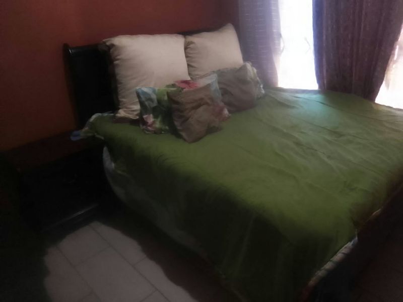 A bedroom featuring tiled flooring and natural light from a window.
