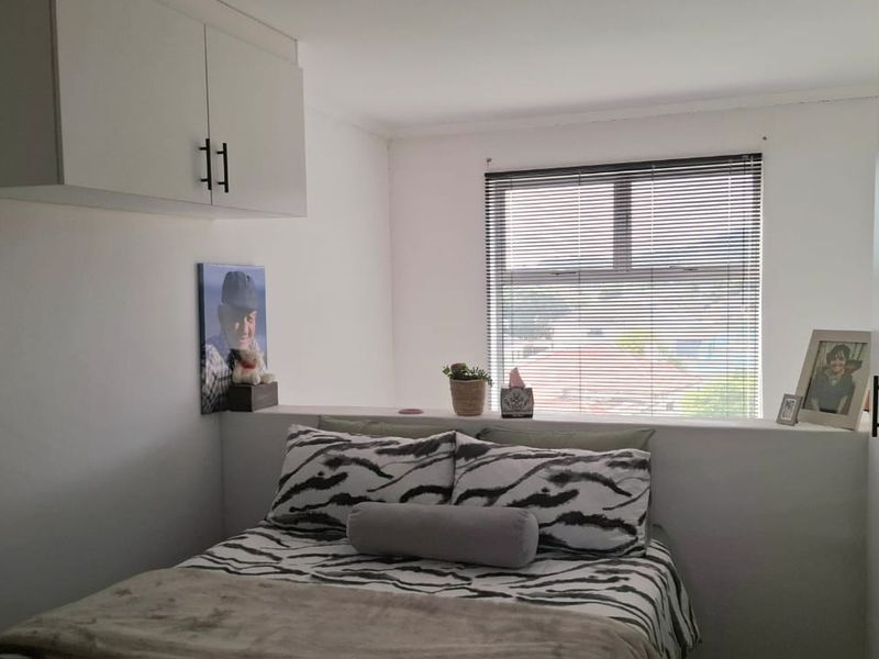 A bedroom featuring built-in cabinetry, a built-in wardrobe, and venetian blinds, providing a functional and compact living space.