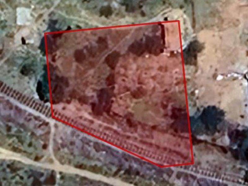 An aerial view of the vacant residential land plot, highlighted with a red boundary overlay.