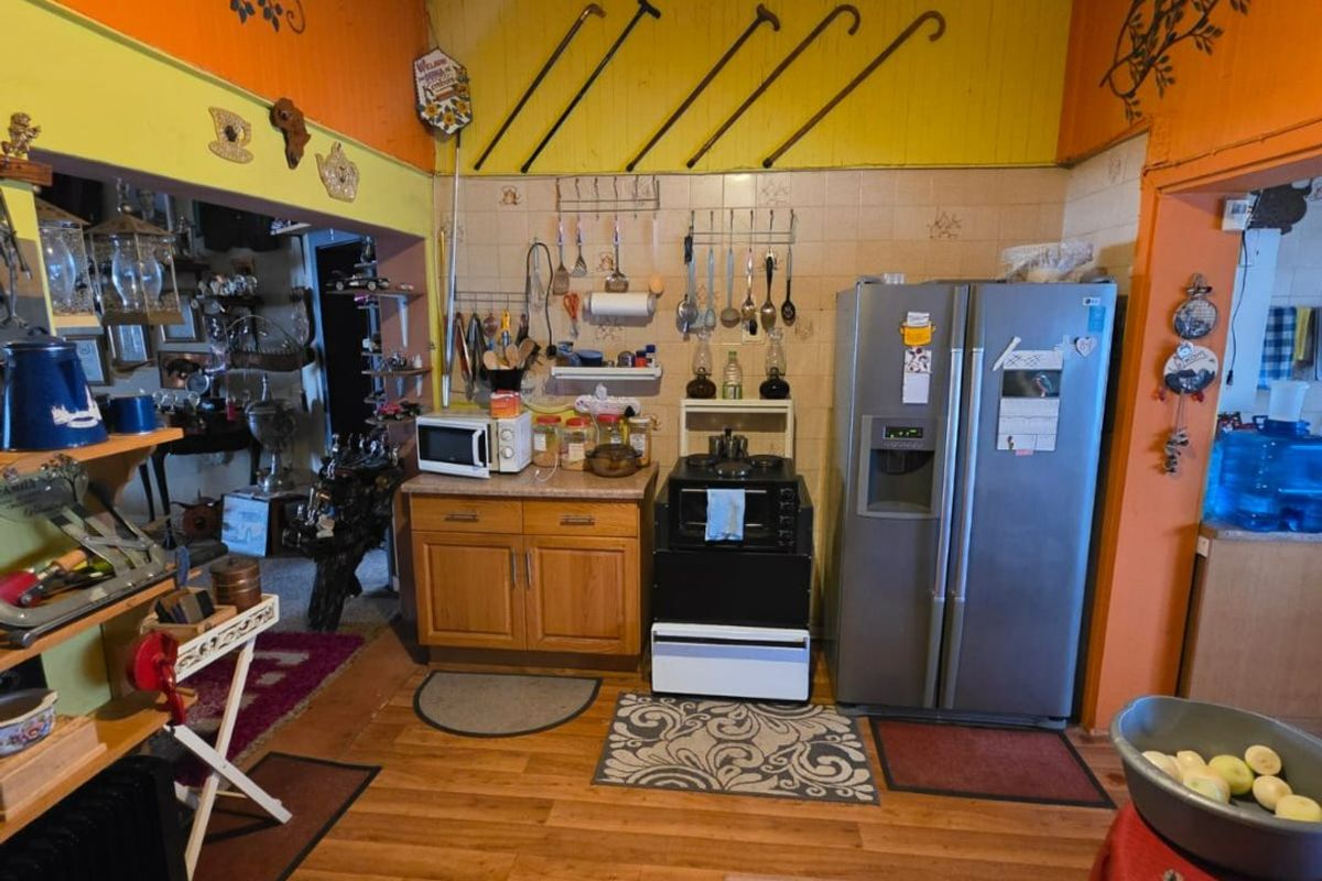 A dated kitchen featuring wooden cabinetry, a tiled backsplash, and a freestanding oven, offering significant potential for modernization and aesthetic improvement.
