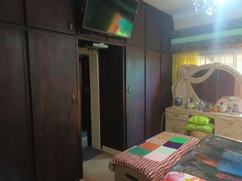 Bedroom featuring extensive dark wood built-in cupboards and a sliding door leading to an adjacent space.