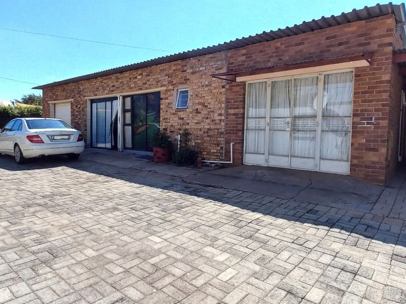 Front exterior view of a face brick house featuring a paved driveway and an attached carport.