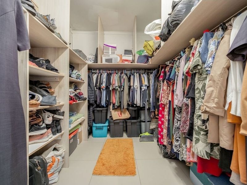 A walk-in closet featuring extensive built-in cabinetry, shelving, and hanging rails, providing ample storage space.