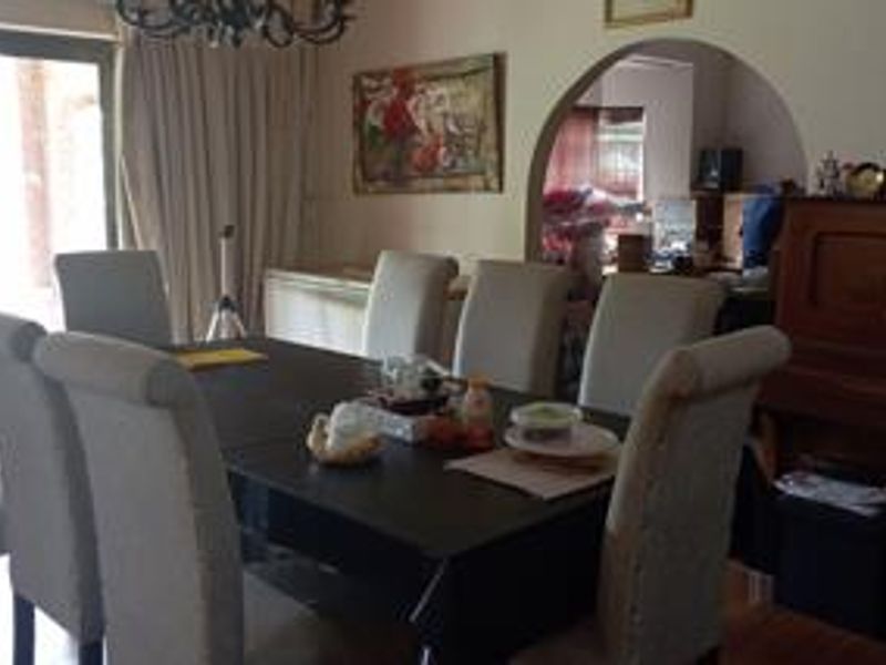 Dining room featuring hardwood flooring, an arched doorway leading to an adjacent space, and a sliding glass door providing access to the exterior.