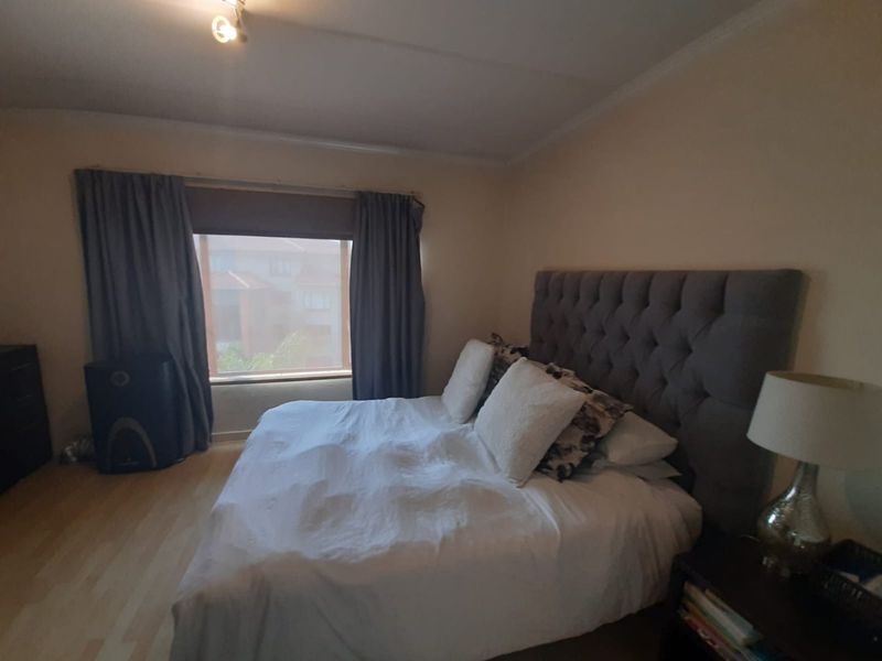 A bedroom featuring laminate flooring and neutral wall finishes, providing a comfortable and functional sleeping space.