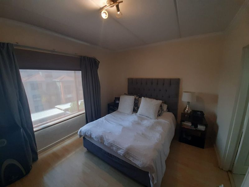 A standard bedroom featuring laminate flooring and a central ceiling light fixture, providing a functional and comfortable sleeping space.