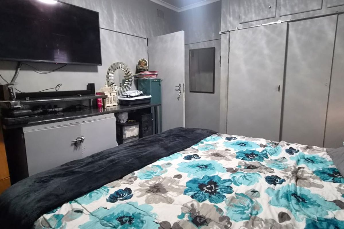 A bedroom featuring built-in cupboards and neutral wall finishes, providing a functional space for rest and storage.
