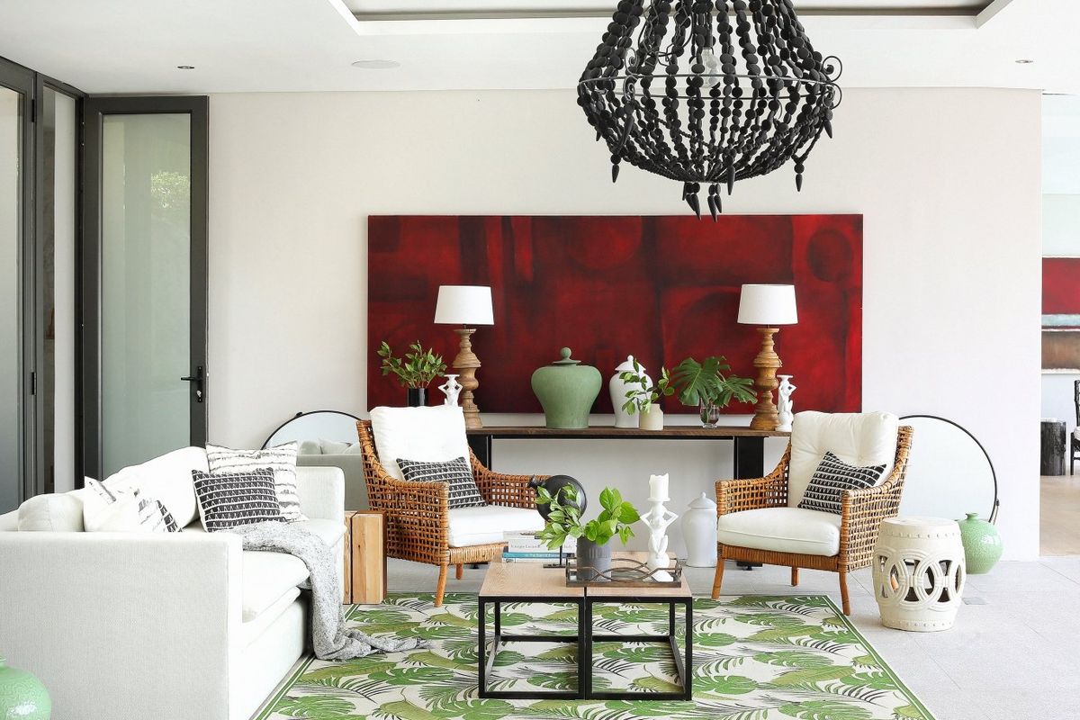 A bright and modern living room featuring tiled flooring, recessed ceiling lighting, and large glass doors leading to an outdoor area.