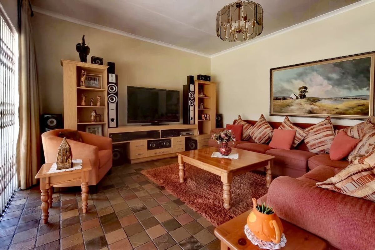 A comfortable living room featuring traditional slate tile flooring and a secure entrance gate, offering a warm and functional space.