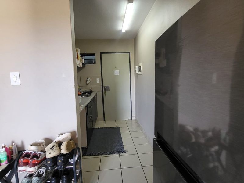A functional kitchen area featuring tiled flooring, built-in cabinetry, and direct access to an internal door.