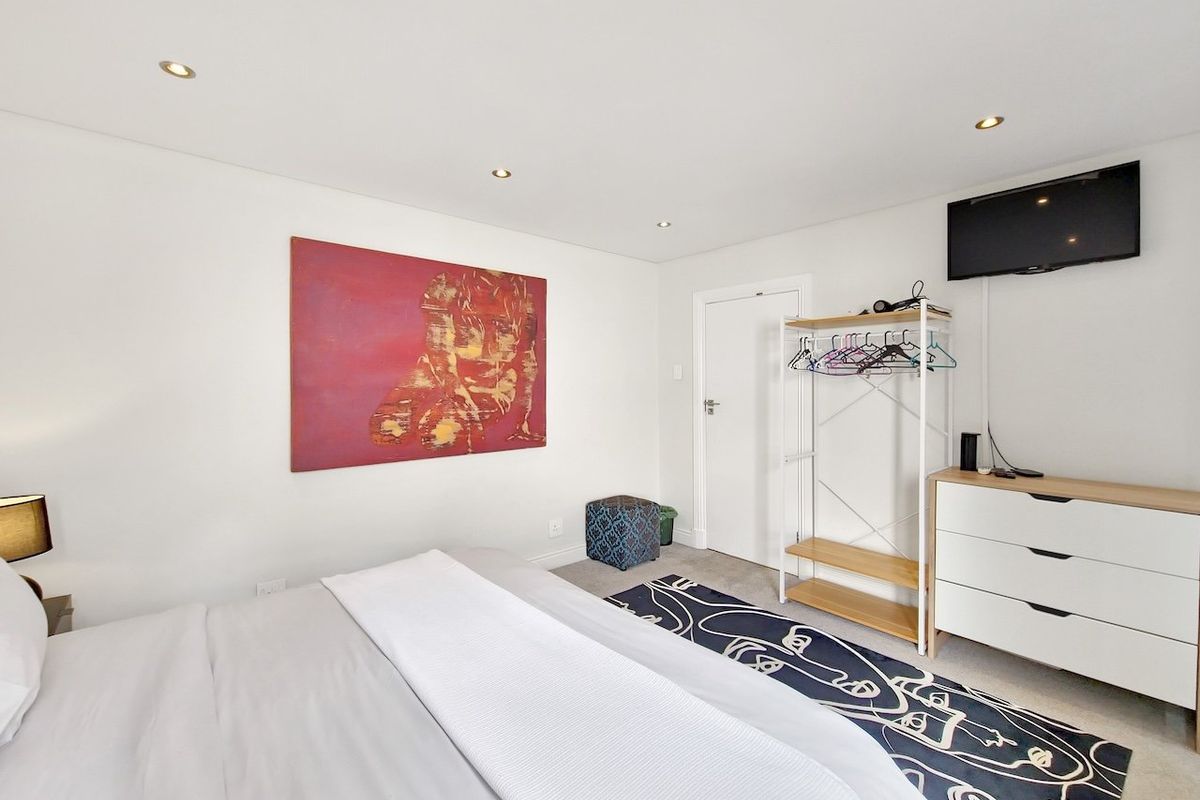 A well-maintained bedroom featuring recessed downlighting and neutral carpeting, providing a clean and functional living space.