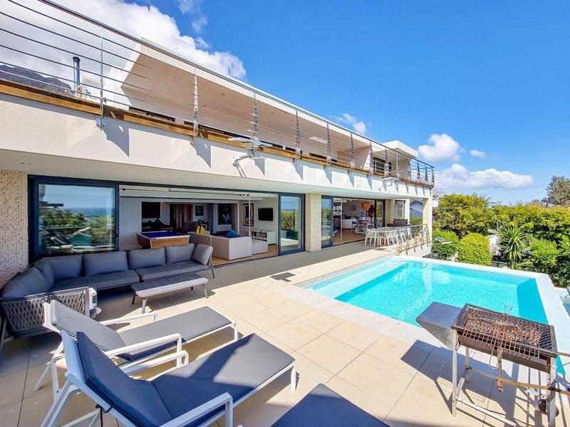 Spacious outdoor pool area featuring a tiled patio, swimming pool, and seamless indoor-outdoor flow through large sliding glass doors to the living space.
