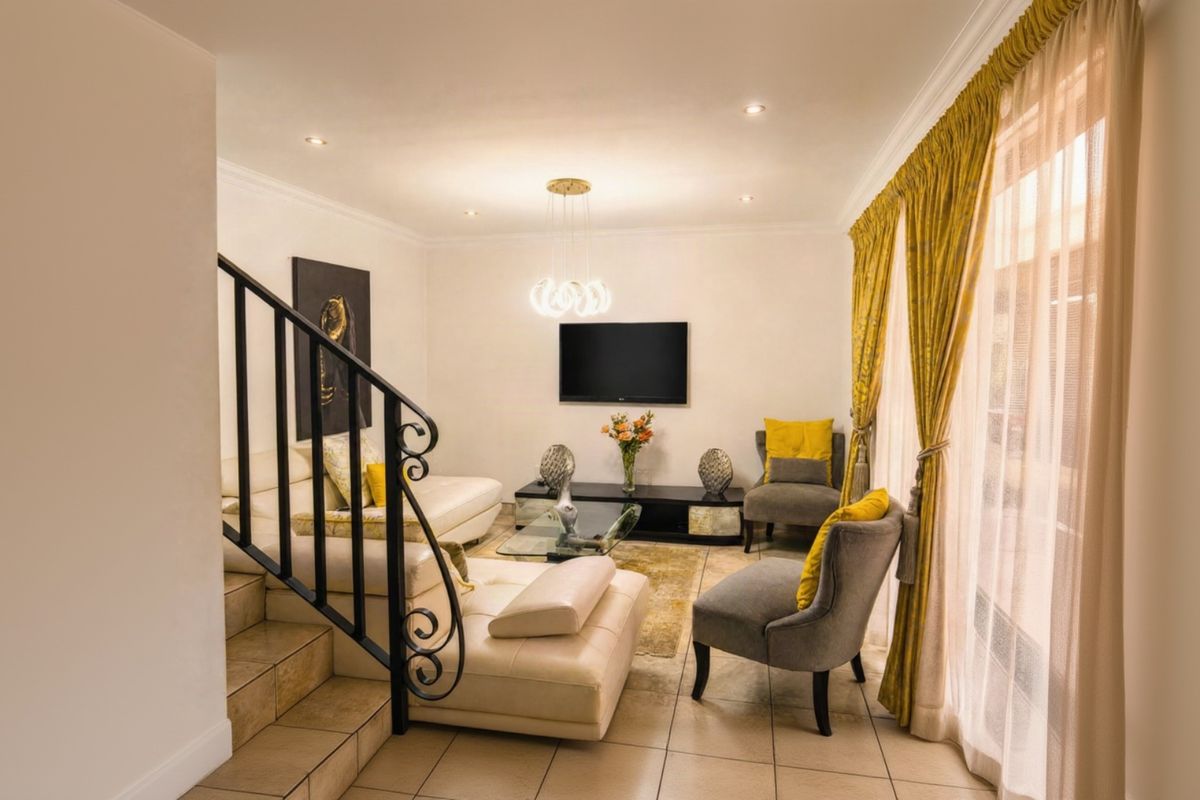 A well-lit living room featuring tiled flooring, a decorative wrought iron staircase railing, and large sliding glass doors leading to the exterior.