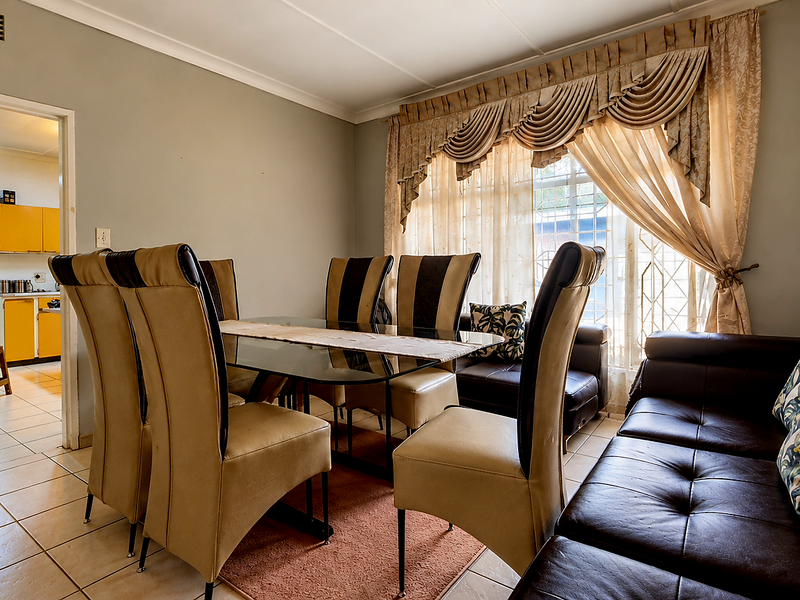 Open plan living and dining area featuring tiled flooring and access to a secondary kitchen space.