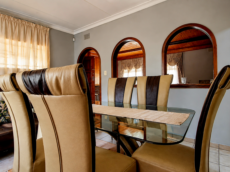 Dining area featuring distinctive arched wall openings, tiled flooring, and coved ceilings, providing a unique architectural transition to the adjacent living space.