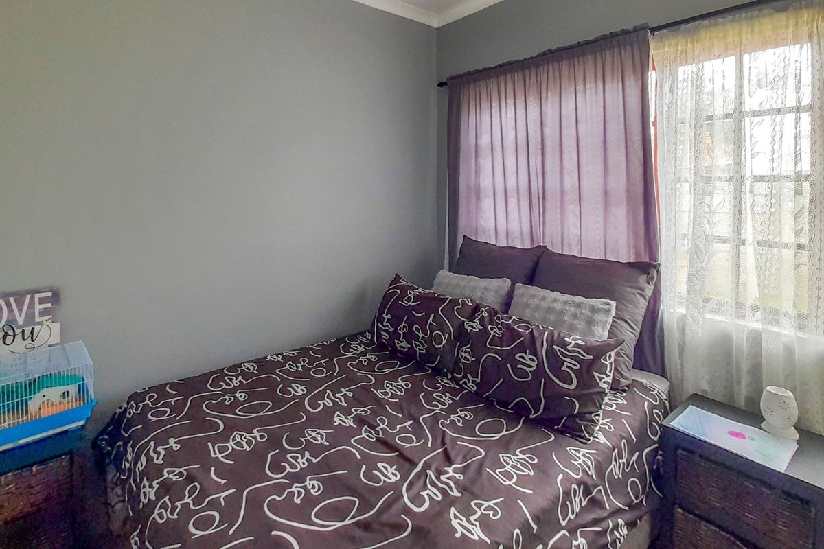 A bedroom featuring a window with installed curtain rods and neutral wall finishes.
