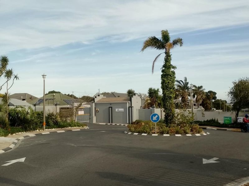 A view of the entrance road and gated access point to the residential apartment complex.