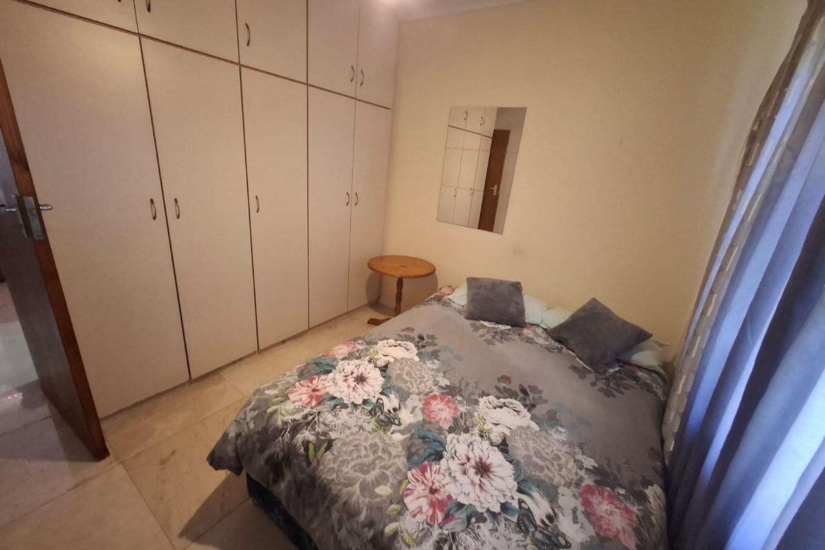 A bedroom featuring built-in cupboards and tiled flooring, providing functional storage and a neutral base for interior design updates.