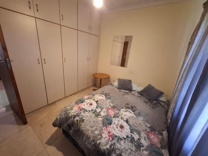 A bedroom featuring built-in cupboards and tiled flooring, providing functional storage and a neutral base for interior design updates.