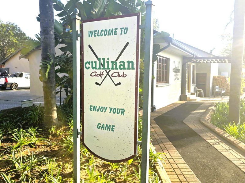 Entrance area of the Cullinan Golf Club featuring a paved walkway, landscaped garden, and club signage.