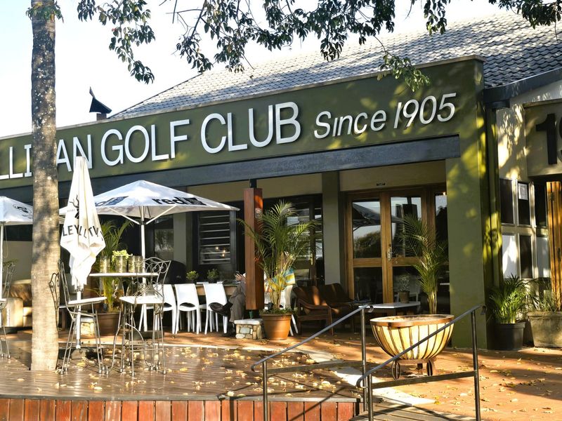 A covered outdoor patio area at the Cullinan Golf Club, featuring timber decking, tiled roofing, and direct access to the clubhouse interior.