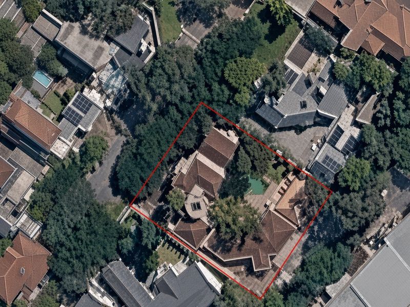 Aerial view of the property showing the house layout, tiled roof structure, swimming pool, and surrounding garden area within the highlighted boundary.