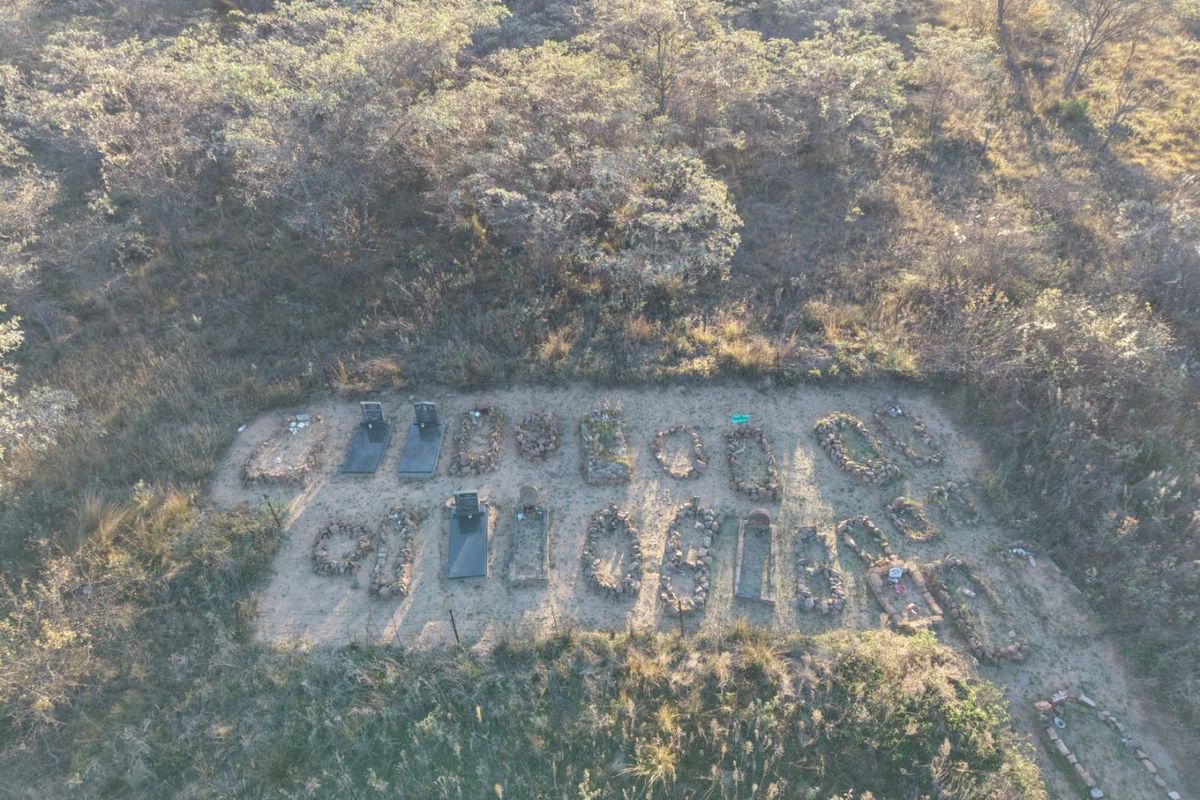 An aerial view of a burial site located on the property grounds, featuring multiple grave markers surrounded by natural vegetation.