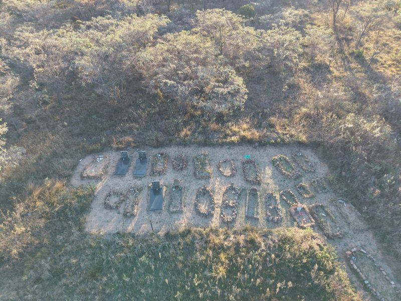 An aerial view of a burial site located on the property grounds, featuring multiple grave markers surrounded by natural vegetation.