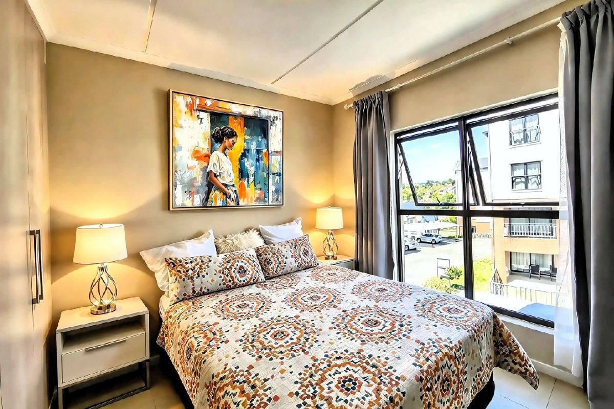 A well-lit bedroom featuring tiled flooring, a built-in wardrobe, and large aluminium-framed windows offering natural light and exterior views.
