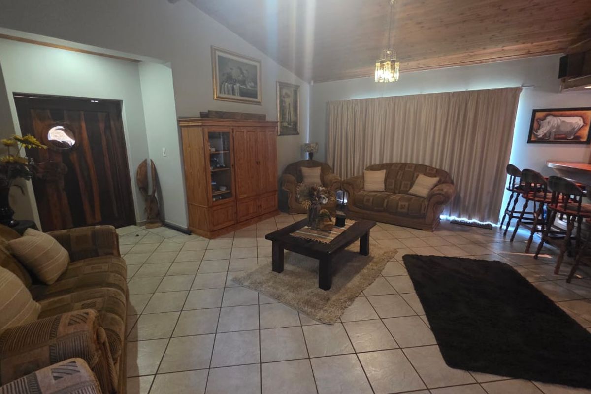 Spacious living room featuring vaulted timber ceilings, tiled flooring, and a built-in bar area, offering a warm and traditional aesthetic.