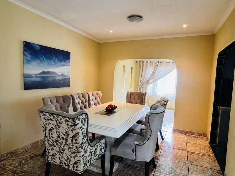A dining room featuring tiled flooring, an arched entryway leading to an adjacent space, and recessed ceiling lighting.