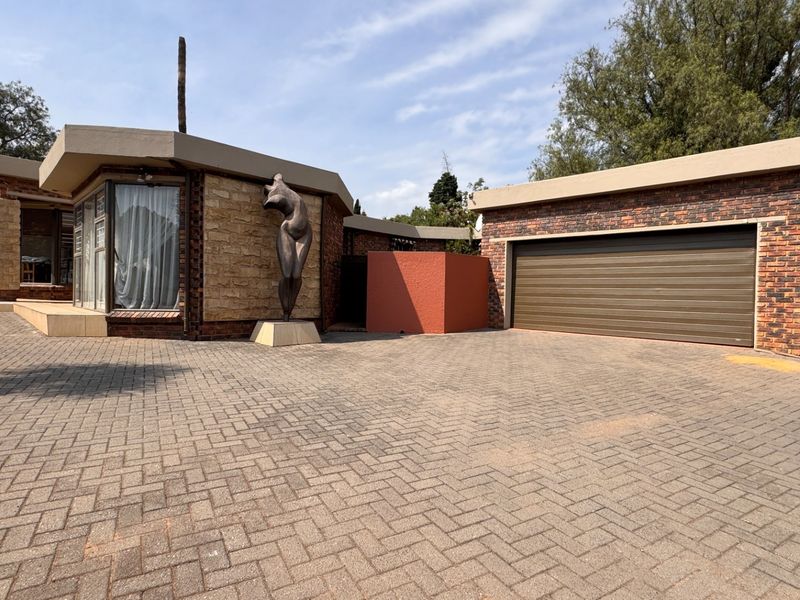 Front elevation of a modern house featuring a brick driveway, face brick exterior, stone accents, and a double garage.