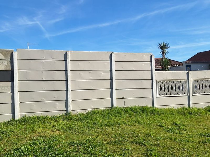 Front view of the property featuring a precast concrete boundary wall with decorative lattice panels and a garage entrance.