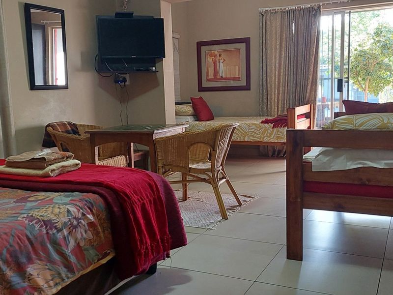 Spacious bedroom featuring tiled flooring and a sliding glass door providing access to the exterior.