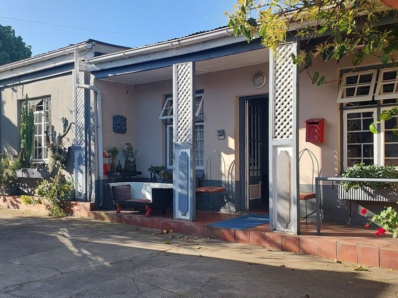 Front elevation of a house featuring a covered veranda with decorative timber posts, tiled flooring, and a concrete driveway approach.