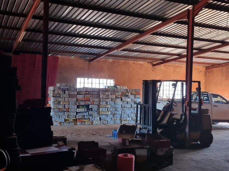 A large industrial utility space or storage shed featuring exposed steel beams, corrugated metal roofing, and concrete flooring, suitable for agricultural or commercial storage.