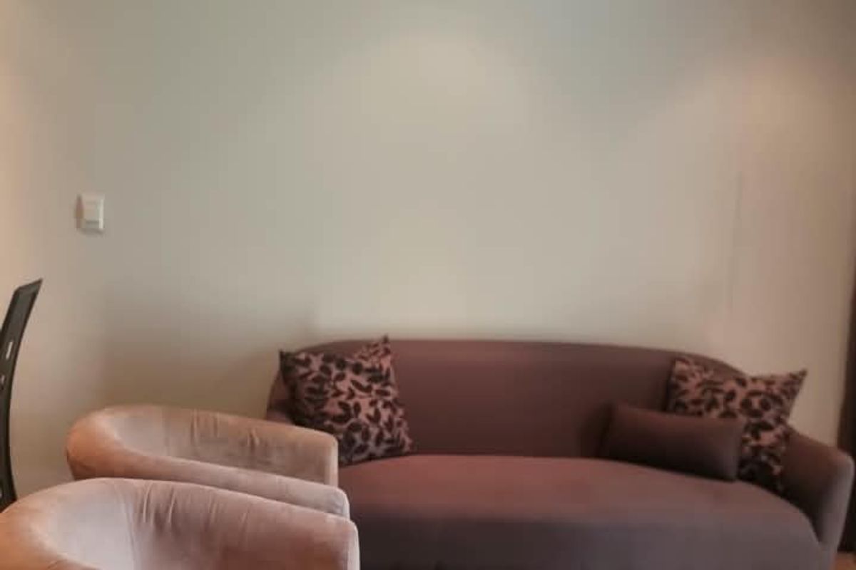 A living room area featuring neutral wall finishes and recessed ceiling lighting.