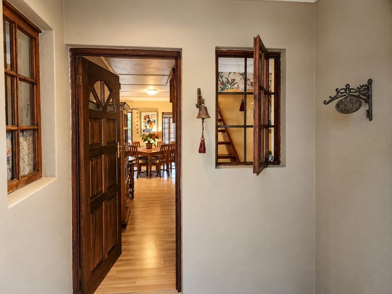 An inviting entryway featuring classic wooden door and window frames, providing a warm transition into the open-plan living and dining area.