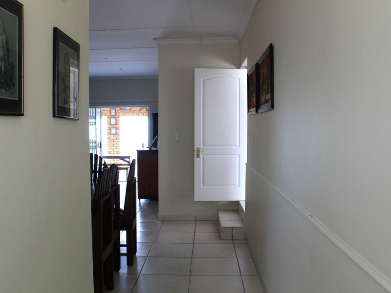 A tiled hallway leading towards an open-plan living area with a view of the rear patio.