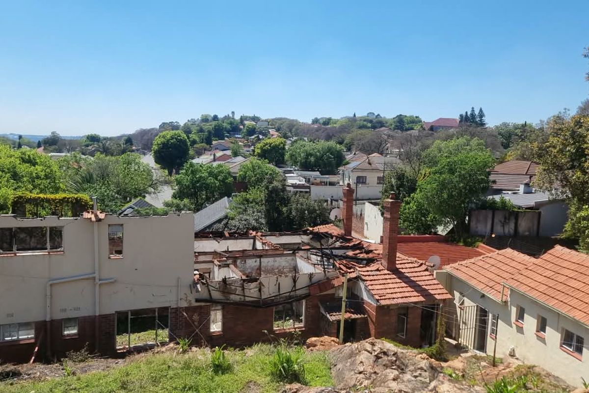 Aerial view of a residential property showing significant structural damage, including a collapsed roof and exposed interior masonry walls.