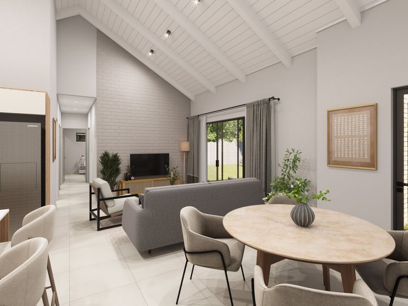 Spacious open-plan living and dining area featuring a high vaulted ceiling with exposed beams, a brick feature wall, and large sliding doors to the garden.