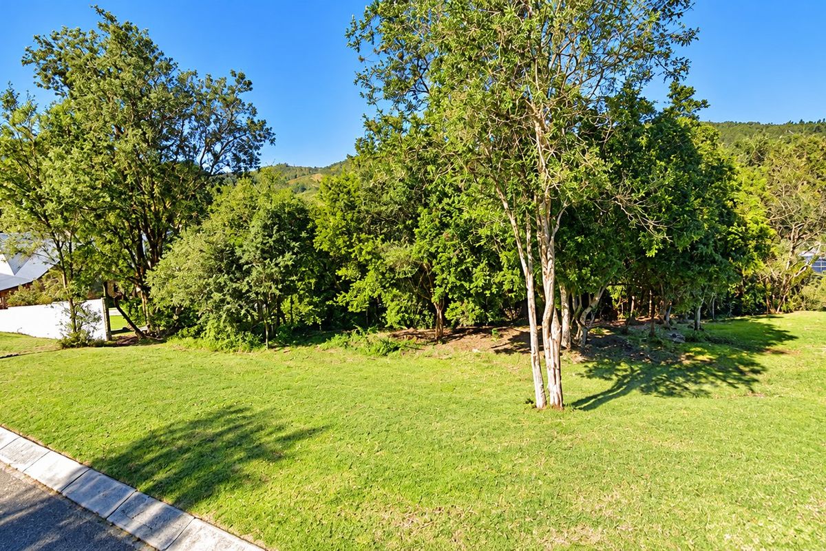 A well-maintained residential plot featuring established trees and a manicured lawn, offering a peaceful and scenic outdoor setting.