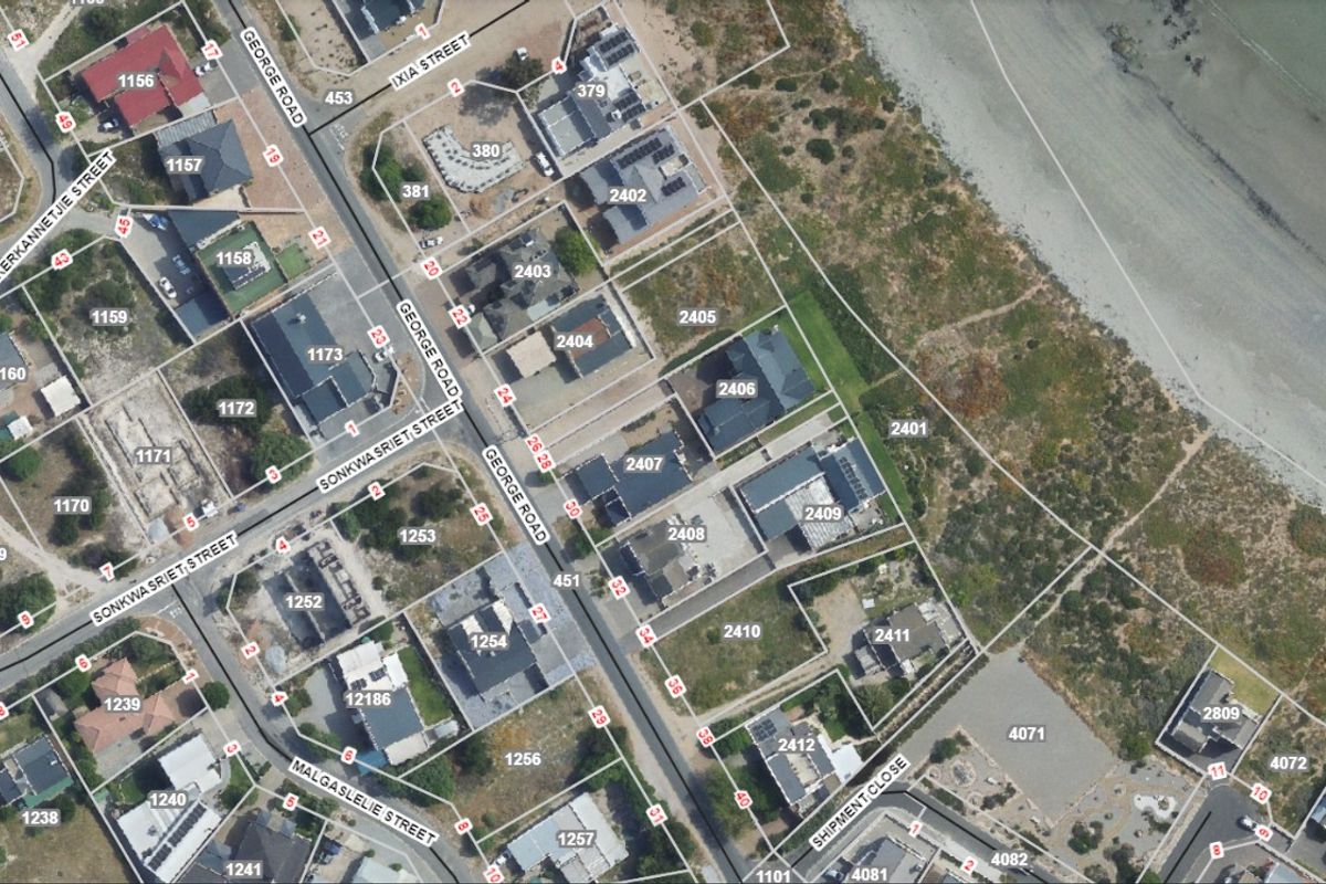 An aerial view showing the residential street layout, property plot boundaries, and proximity to the coastline.