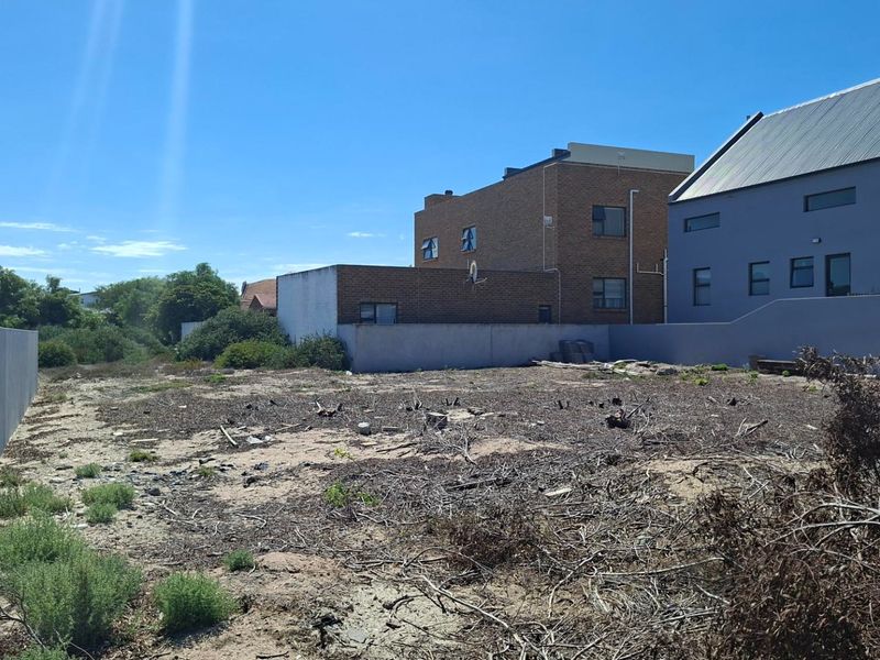 A vacant residential plot featuring boundary walls and surrounding residential development, offering a blank canvas for future construction.