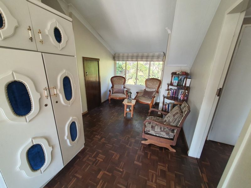 A bedroom featuring parquet flooring, a sloped ceiling, and a built-in wardrobe with decorative detailing.