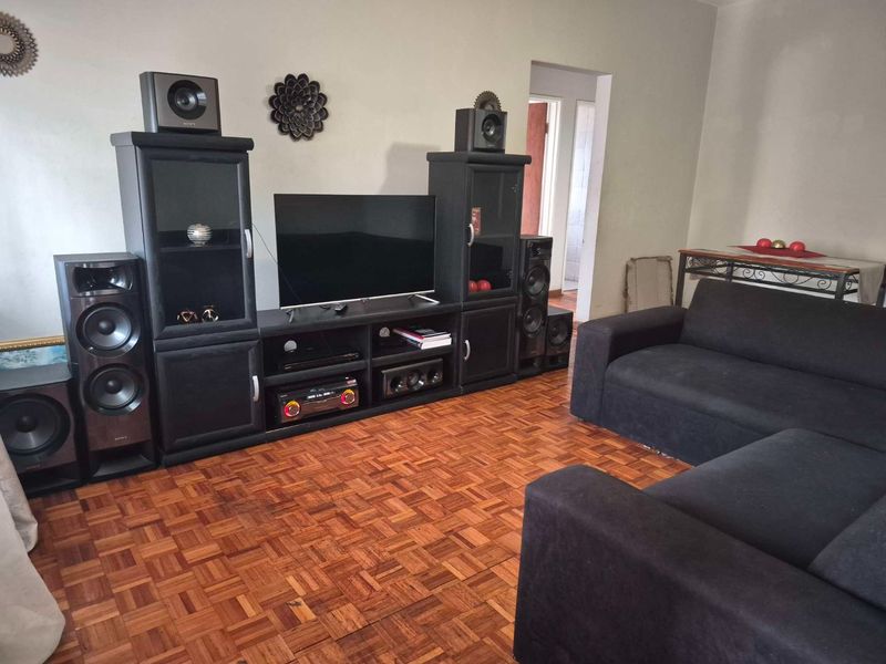 A living room featuring classic parquet wood flooring and neutral wall finishes, providing a solid foundation for interior updates.