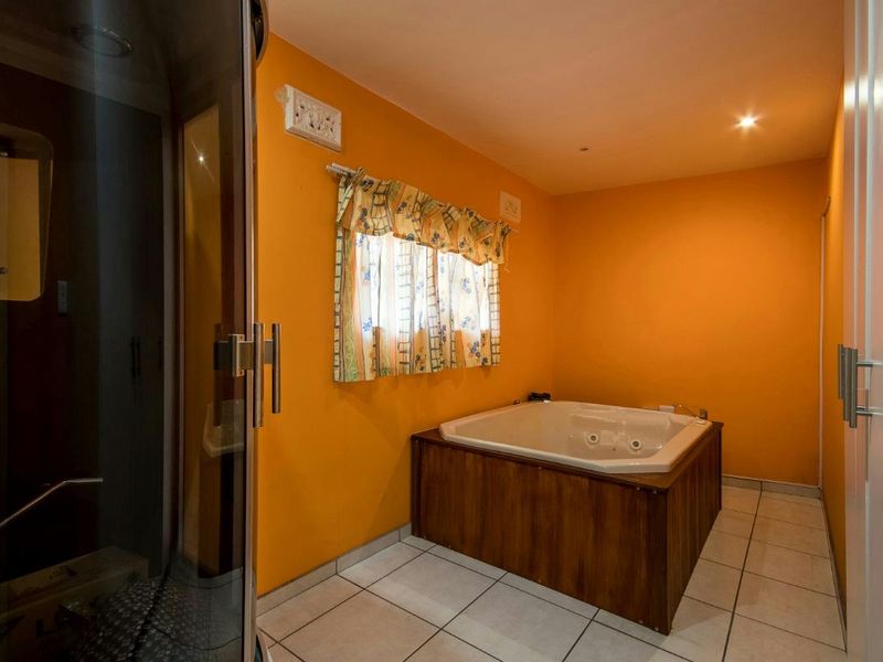 Bathroom featuring a built-in spa bath with wood-look paneling, a separate enclosed shower cubicle, and tiled flooring.