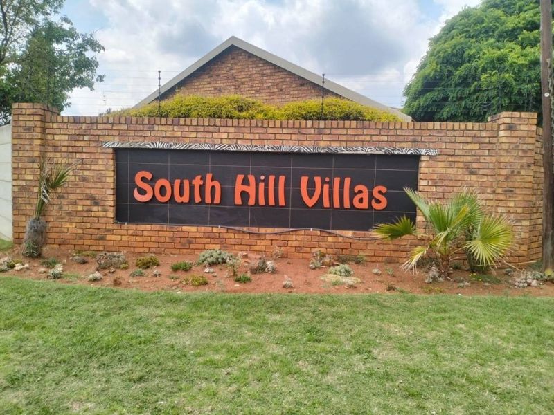 The entrance signage and brick boundary wall for South Hill Villas, featuring integrated electric fencing.